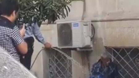 Bakıda polis küçədə yatan kişini çimizdirdi