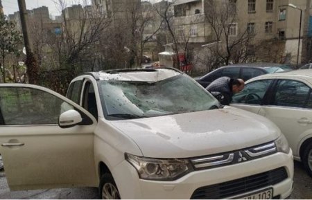 Güclü külək Bakıda su çənini avtomobilin üstünə atdı